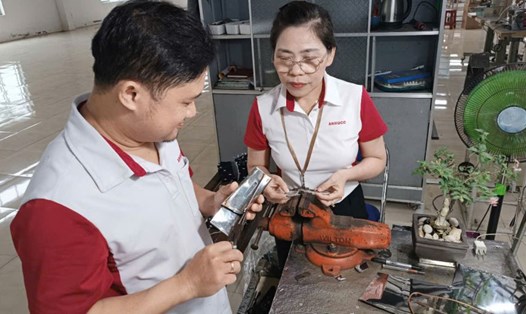Chị Trần Thị Thanh Chung - Chuyền trưởng chuyền may, Xí nghiệp May An Thịnh (thuộc Công ty Cổ phần An Hưng, tỉnh Phú Yên) hướng dẫn công nhân kỹ thuật may mới. Ảnh: Phương Thảo