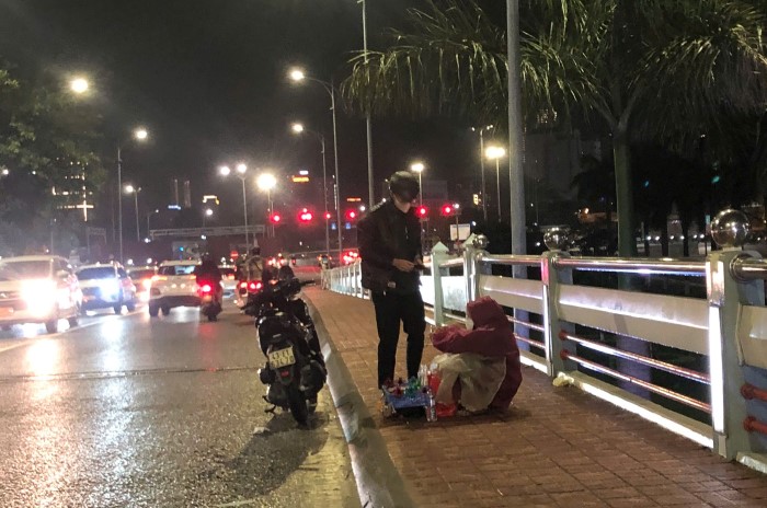 Mot cu gia hon 70 tuoi ngoi ban ve so, hang rong tren Cau Song Han duoc nguoi di duong dung lai mua ung ho. Anh: Song Han
