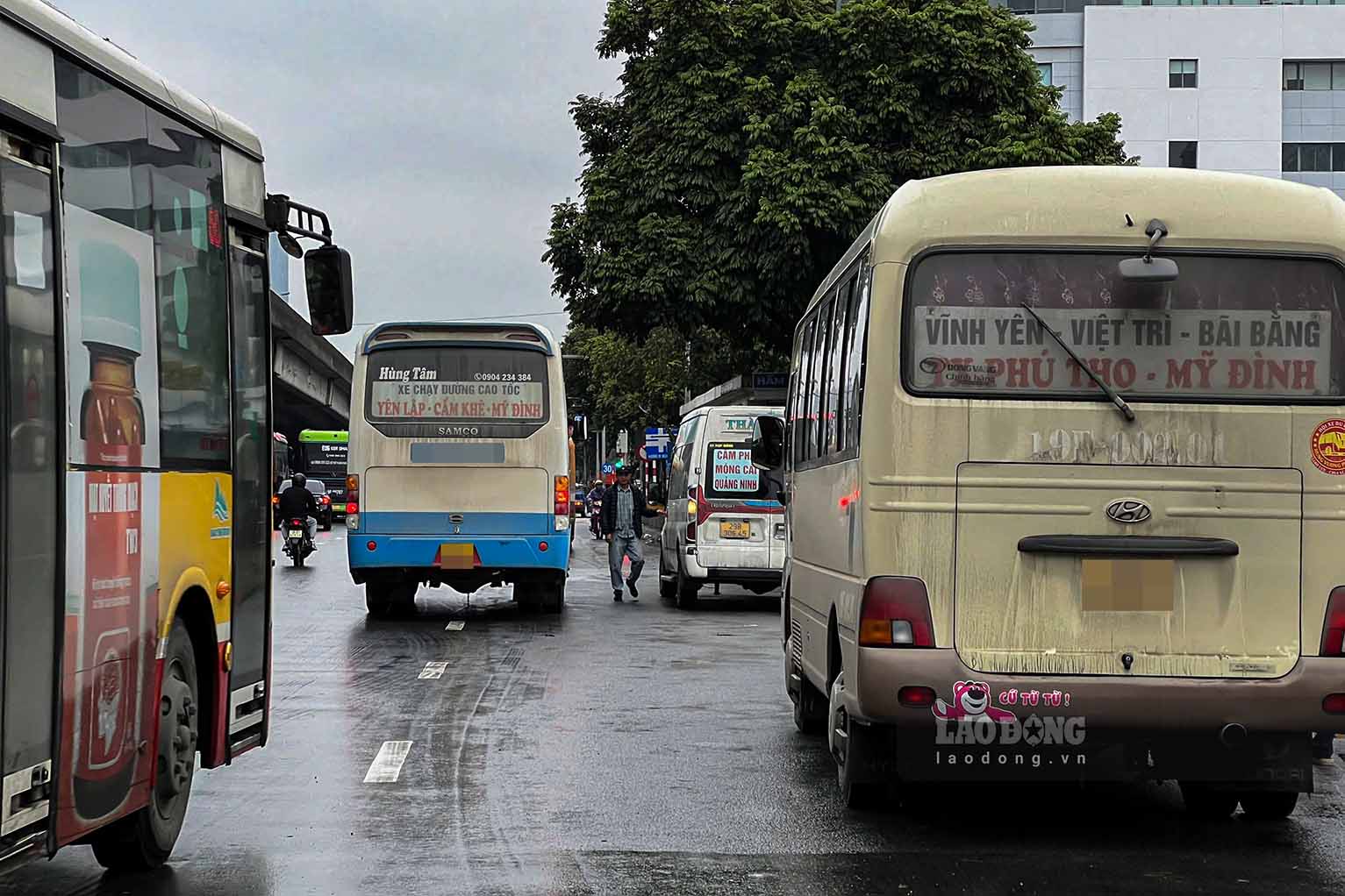 Mot nha xe cho xe khach do giua duong, nhan vien phu xe ke ghe ngoi doi khach.