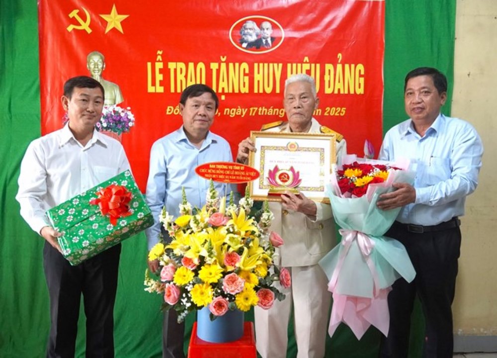 Pho Bi thu Thuong truc Tinh uy Phan Van Thang (thu 2 ben trai qua) trao Huy hieu 65 nam tuoi Dang va chuc mung cho dang vien Le Hoang Ai Viet. Anh: Cong thong tin dien tu Dong Thap.