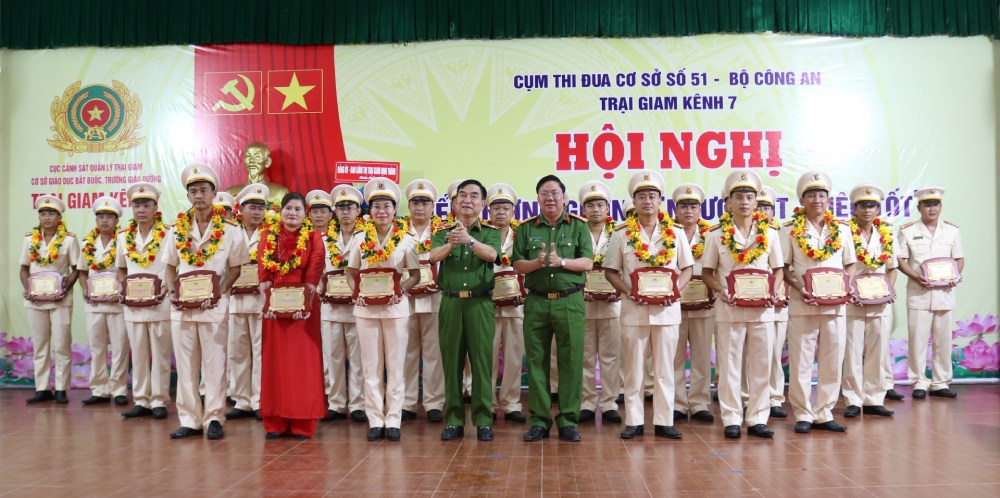 Major General Nguyen Viet Hung (blue uniform on the left) and Colonel Le The Ty (blue uniform on the right) presented flowers and symbols to collectives and individuals with good and creative ways of doing things in the emulation movement "For National Security" for the period 2020-2025. Photo: Van Vu