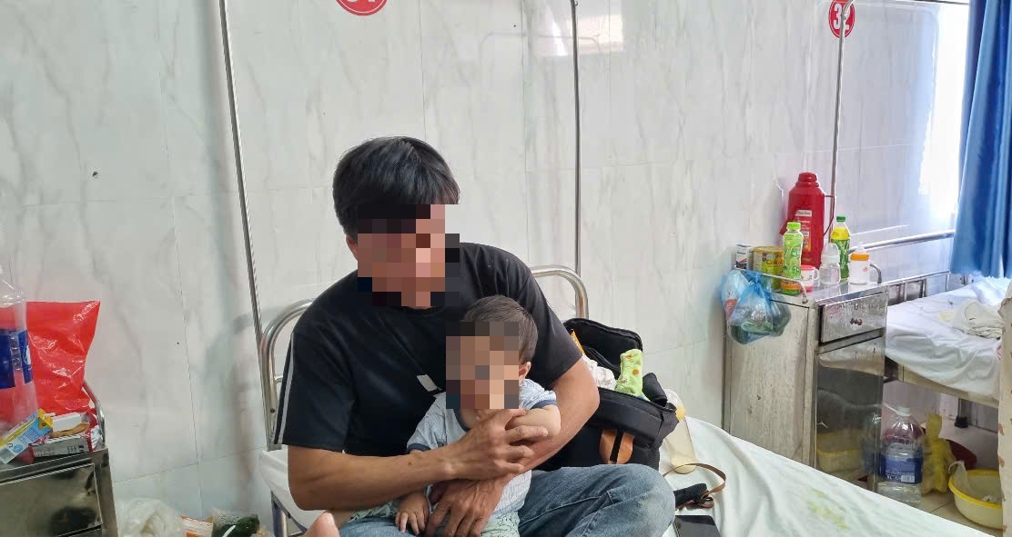 Mr. D.V.N takes care of his daughter with facial bruises at the Central Highlands General Hospital. Photo: Bao Trung