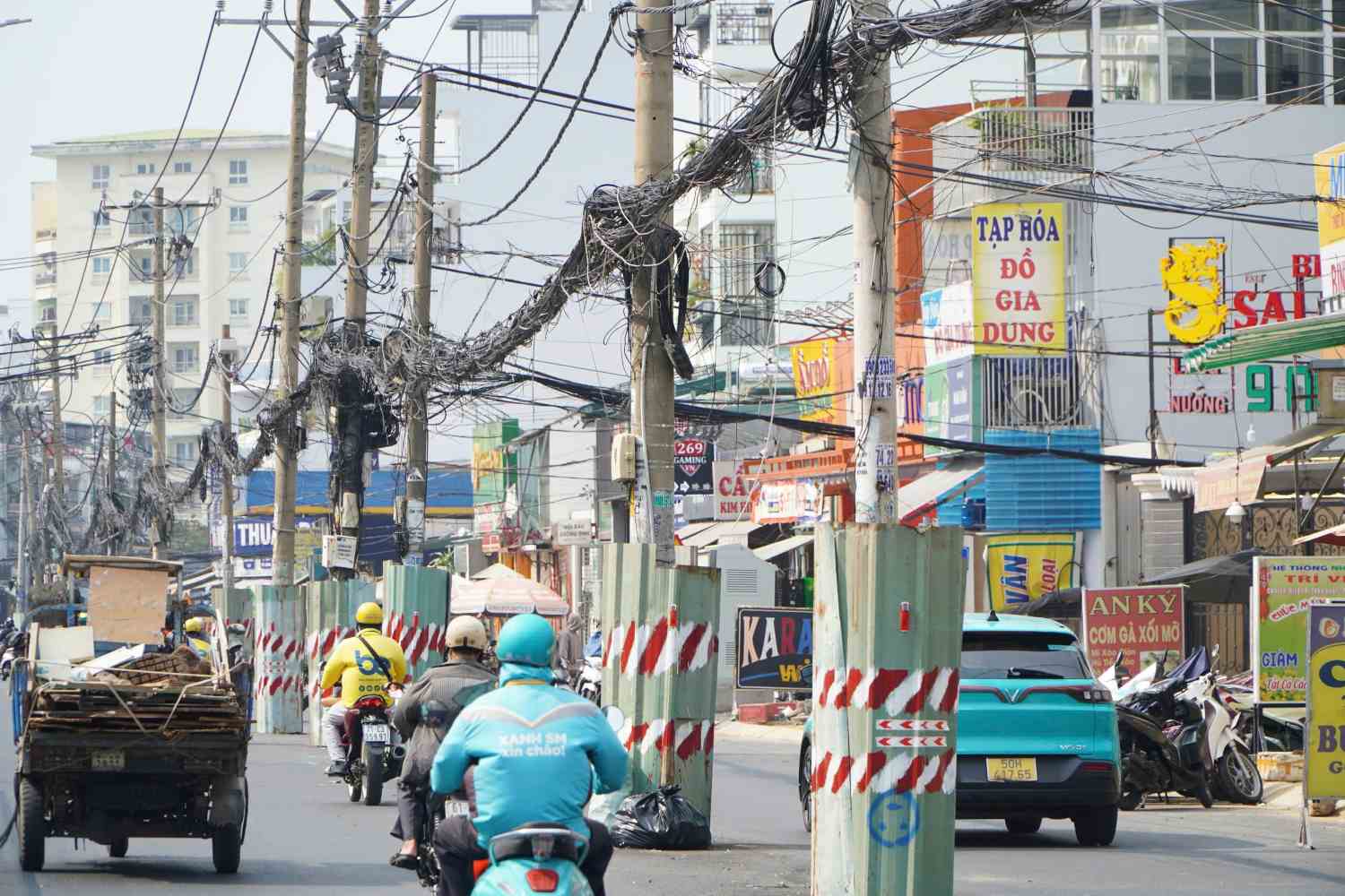 Cot dien o duong Duong Quang Ham dang duoc rao chan ton xung quanh, son phan quang trang do.  Anh: Anh Tu