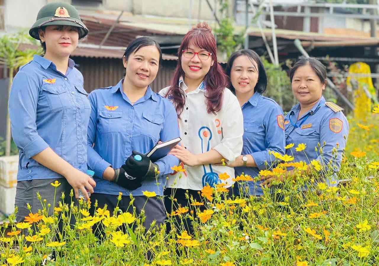 Nu cong nhan lao dong nganh duong sat chup hinh ben duong hoa. Anh: HAC