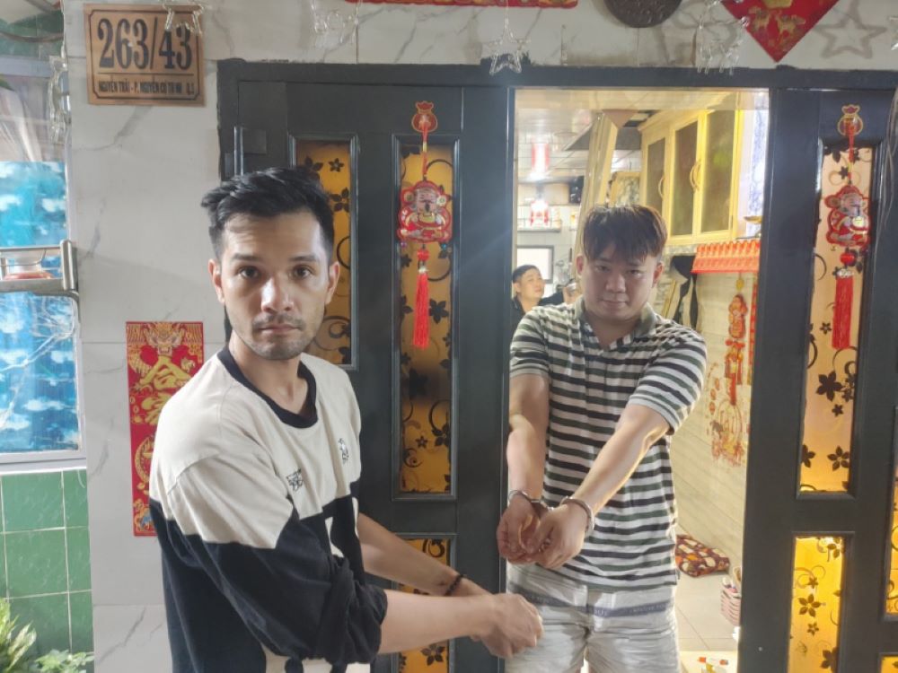 Nhikolai Đinh (bên trái) diễn tả lại cảnh mua ma túy từ đối tượng Trịnh Bá Hóa (con trai của Trịnh Thị Hòa). Ảnh: Công an cung cấp
