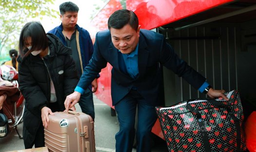 Ông Nguyễn Đình Thắng - Ủy viên Ban chấp hành Tổng LĐLĐVN, Chủ tịch Công đoàn Các khu công nghiệp - chế xuất Hà Nội hỗ trợ công nhân lấy hành lý khi xe về đến Hà Nội. Ảnh: Hải Nguyễn