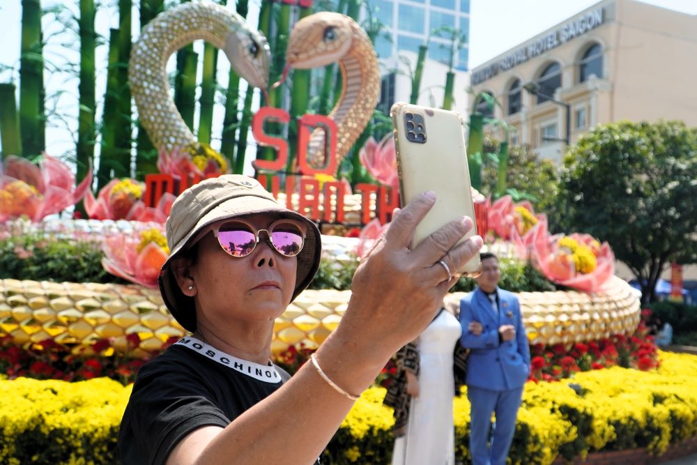 Khong chi nguoi dan TP.HCM tranh thu tham quan duong hoa Nguyen Hue trong ngay cuoi cung mo cua, ma con co rat nhieu nguoi tu cac tinh tro lai TP nay sau Tet de hoc tap, lam viec.  Anh Nguyen Van Long dua gia dinh tu TP Thu Duc len duong hoa de vui choi. “Nhung ngay Tet phai ve que nen hom nay tranh thu bua cuoi duong hoa mo cua de len day chup anh. Coi hinh anh duong hoa qua mang da an tuong roi ma den day con thay dep hon nhieu, ca nha tha ho co nhieu anh dep” - anh Long noi.