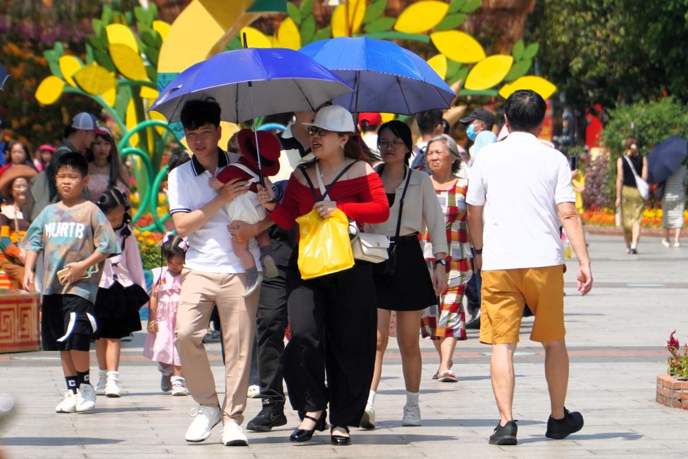 Nhieu nguoi da chuan bi san o de che nang, quat cam tay trong buoi dao choi dau xuan. Nhung chiec non la la phu kien chup anh voi ao dai cung phat huy tac dung.  