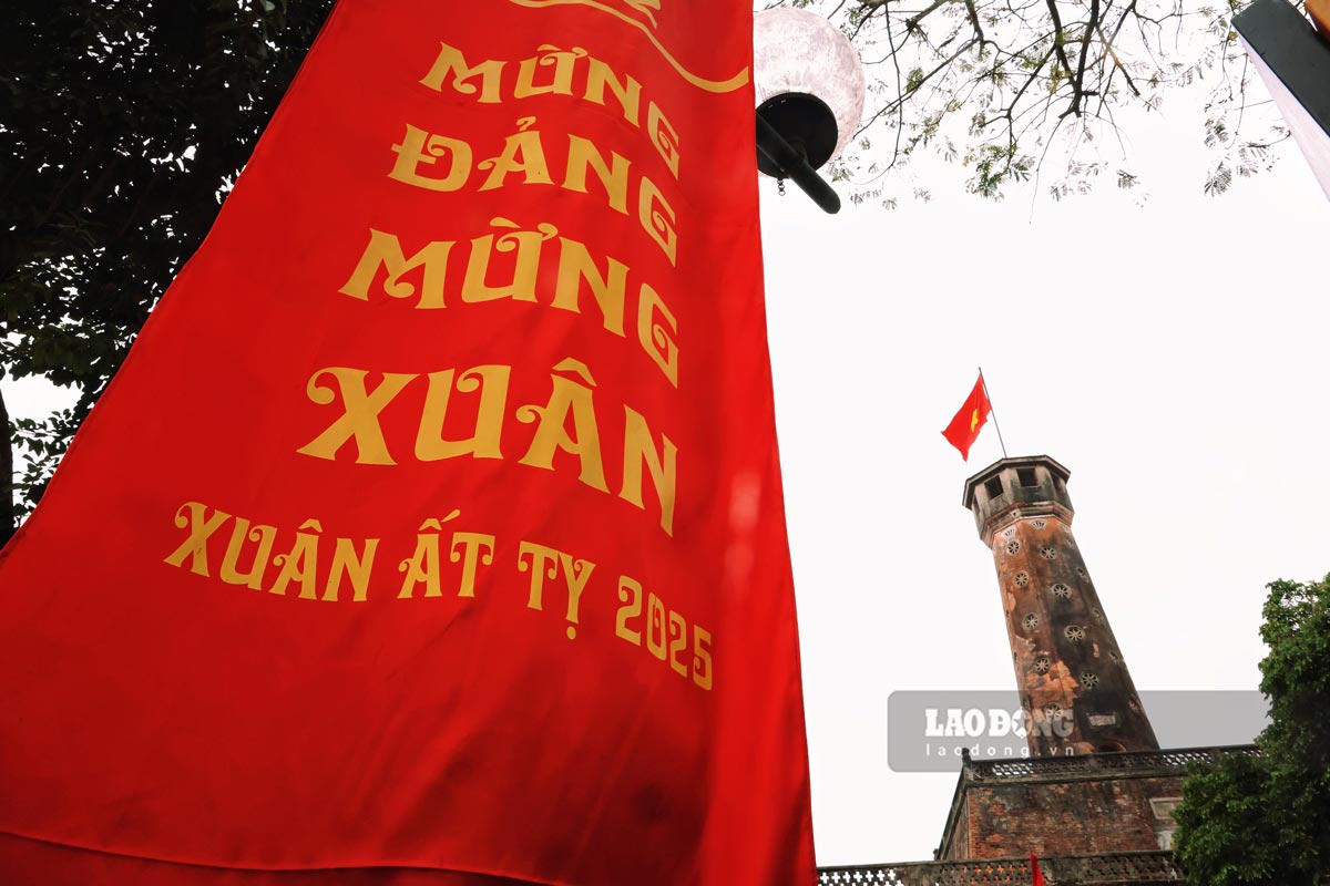 Cot co Ha Noi - bieu tuong kieu hanh cua Thu do ngan nam van hien cung duoc trang tri bang ron voi khau hieu “Mung Dang mung Xuan“.