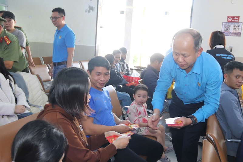 Vice President of Da Nang City Labor Federation Le Van Dai gives lucky money to workers and their relatives before boarding the Union train to return home to celebrate Tet and reunite with their families. Photo: Nguyen Linh
