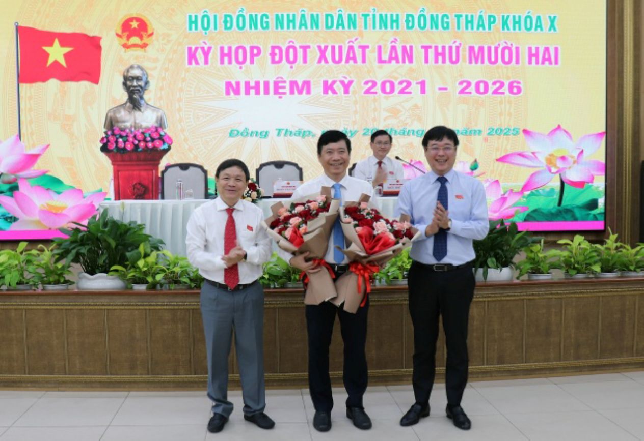 Ong Le Quoc Phong va Phan Van Thang tang hoa chia tay sau khi ong Pham Thien Nghia (giua anh) duoc dai bieu HDND tinh bieu quyet mien nhiem chuc vu Chu tich UBND tinh Dong Thap. Anh:  Cong thong tin dien tu tinh Dong Thap