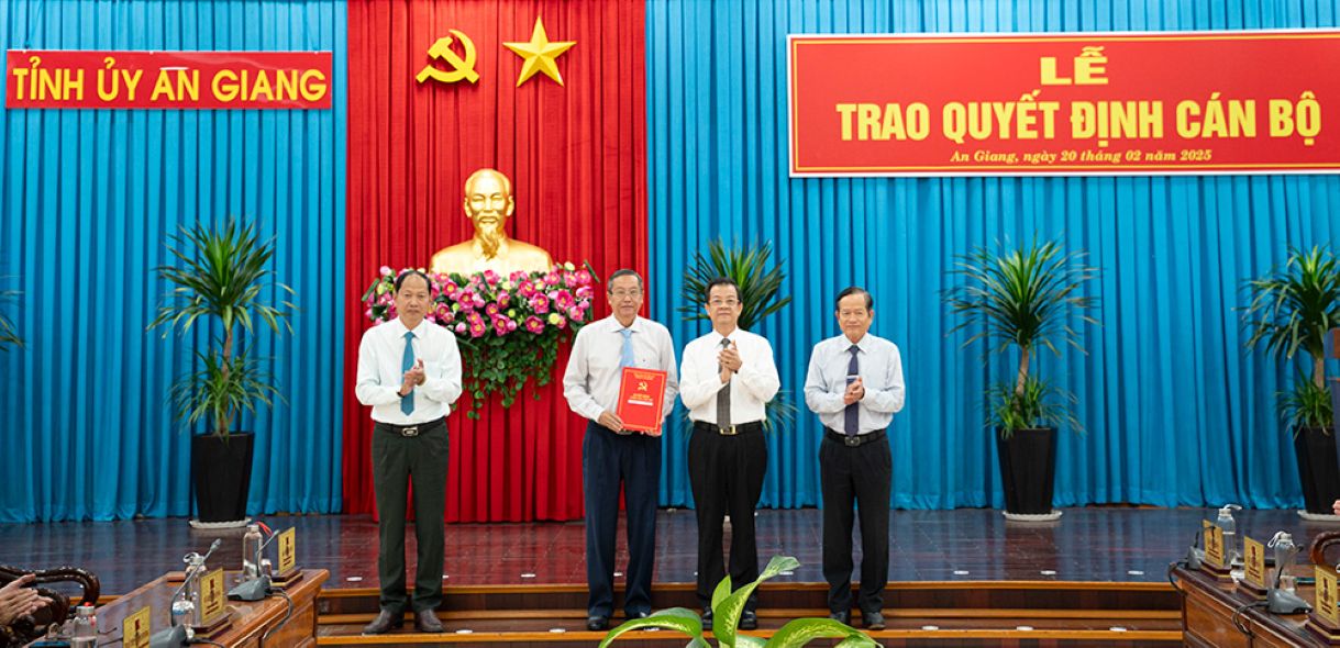 Bi thu Tinh uy An Giang Le Hong Quang trao quyet dinh va tang hoa chuc mung ong Le Van Nung - Pho Bi thu Thuong truc Tinh uy, Chu tich HDND tinh An Giang giu chuc Bi thu Dang uy cac co quan Dang tinh. Anh: Cong thong tin dien tu tinh An Giang