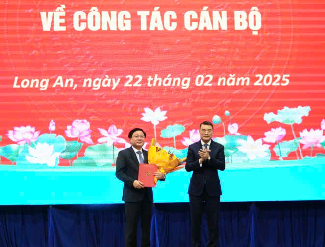 Politburo member and Head of the Central Organizing Committee Le Minh Hung presented the decision to the new Secretary of the Long An Provincial Party Committee Nguyen Van Quyet. Photo: Duy Minh