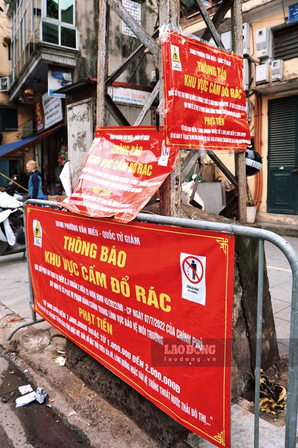 Mot cot dien o pho Quoc Tu Giam (Dong Da, Ha Noi) phai treo 4 bien cam do rac.