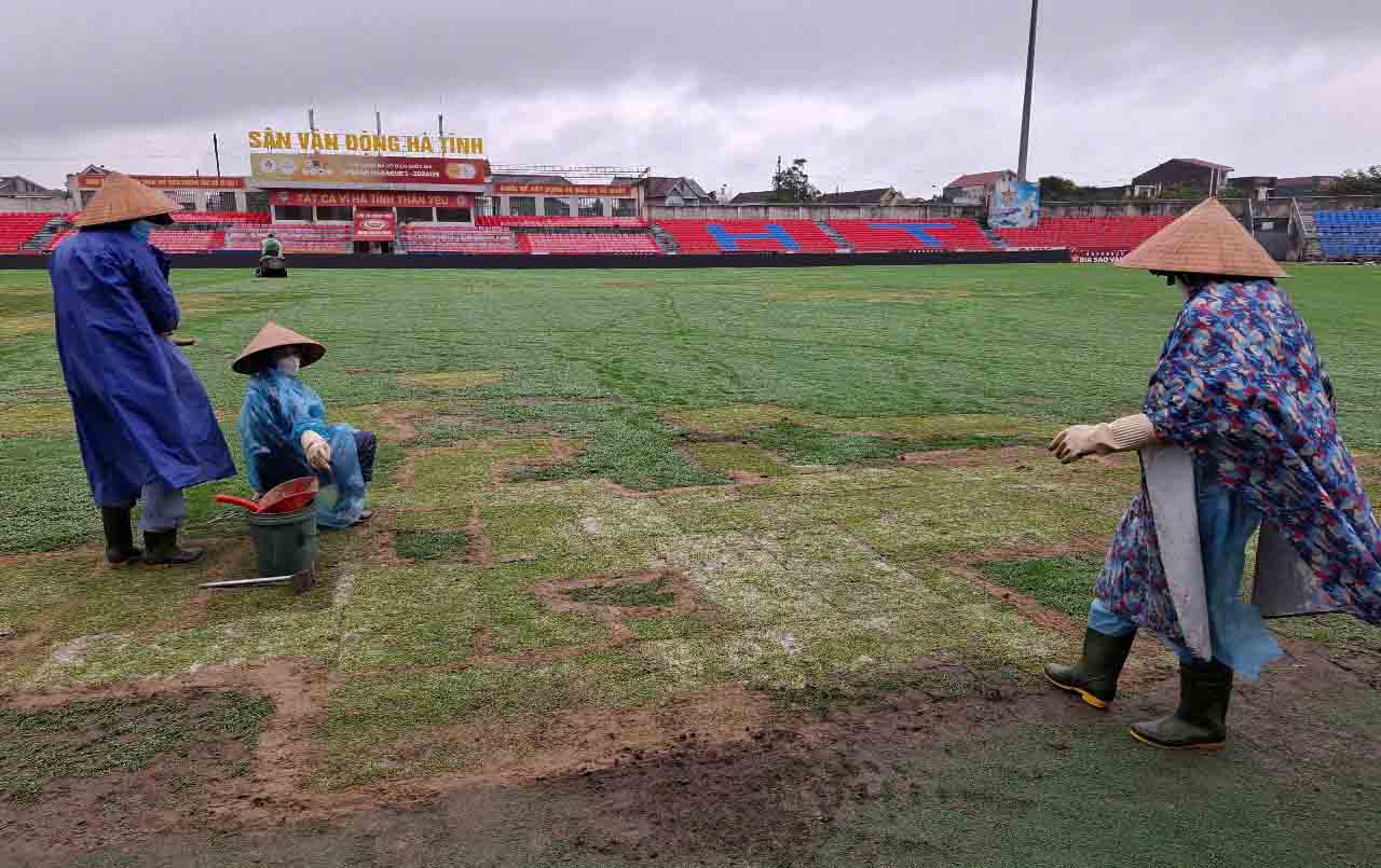 Workers patch the grass at Ha Tinh Provincial Stadium. Photo: Tran Tuan
