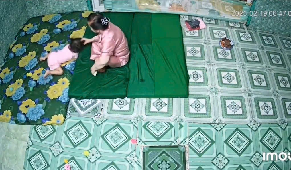 Hình ảnh bà Liên nắm tóc, ghì đầu cháu bé tại cơ sở giữ trẻ trái phép ở Long An. Ảnh cắt từ clip