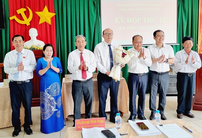 Long Thanh District leaders presented flowers to congratulate the new Chairman of Binh Son Commune People's Committee (in the middle, holding flowers). Photo: HAC