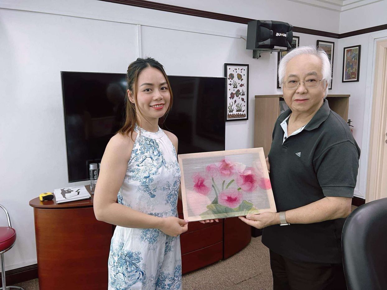 Họa sĩ Hương Giang tặng tranh cho nhà sưu tầm người Singapore đam mê tranh dân gian Việt Nam. Ảnh: Nhân vật cung cấp