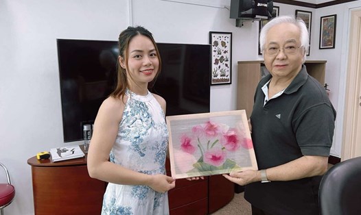 Họa sĩ Hương Giang tặng tranh cho nhà sưu tầm người Singapore đam mê tranh dân gian Việt Nam. Ảnh: Nhân vật cung cấp