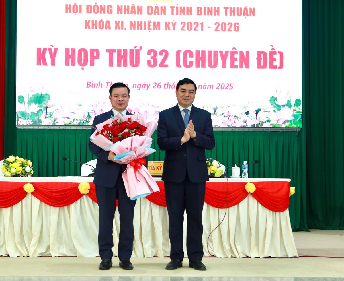 Ong Nguyen Hoai Anh, Bi thu Tinh uy, Chu tich HDND tinh Binh Thuan tang hoa chuc mung ong Do Huu Huy, Pho Bi thu Tinh uy Binh Thuan duoc bau giu chuc Chu tich UBND tinh Binh Thuan. Anh: Duy Tuan 