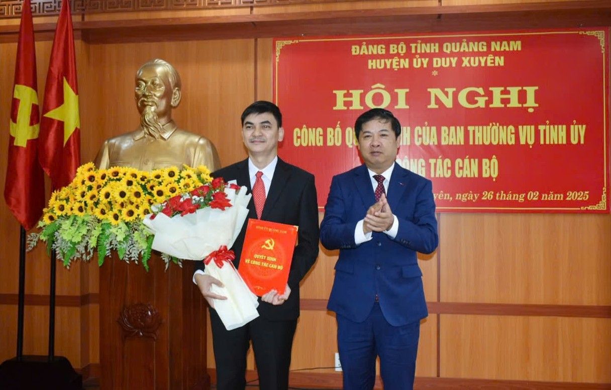 Bi thu Tinh uy Quang Nam Luong Nguyen Minh Triet trao quyet dinh va tang hoa chuc mung ong Cao Thanh Hai (bia trai). Anh: NGUYEN SU