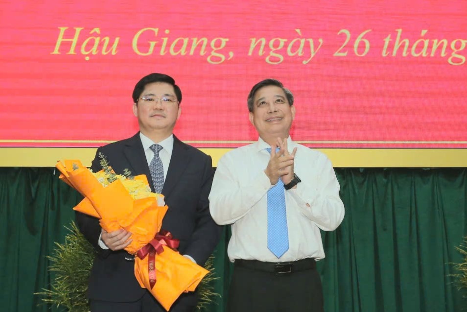 Bi thu Tinh uy Hau Giang Dong Van Thanh tang hoa chuc mung ong Nguyen Tuan Anh. Anh: Ta Quang