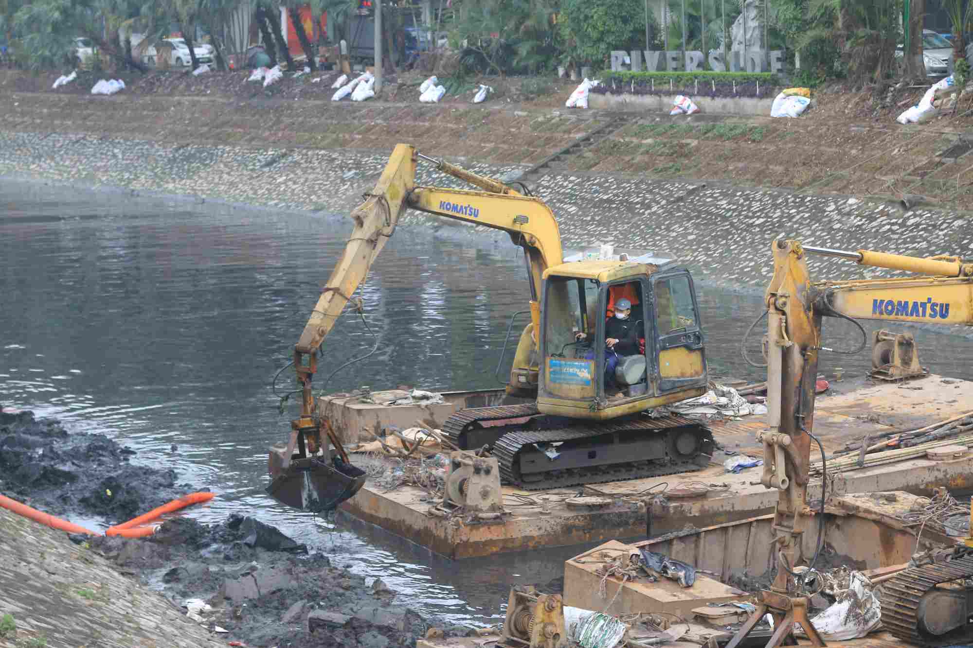 Workers dredging sludge on To Lich River. Photo: Khanh An