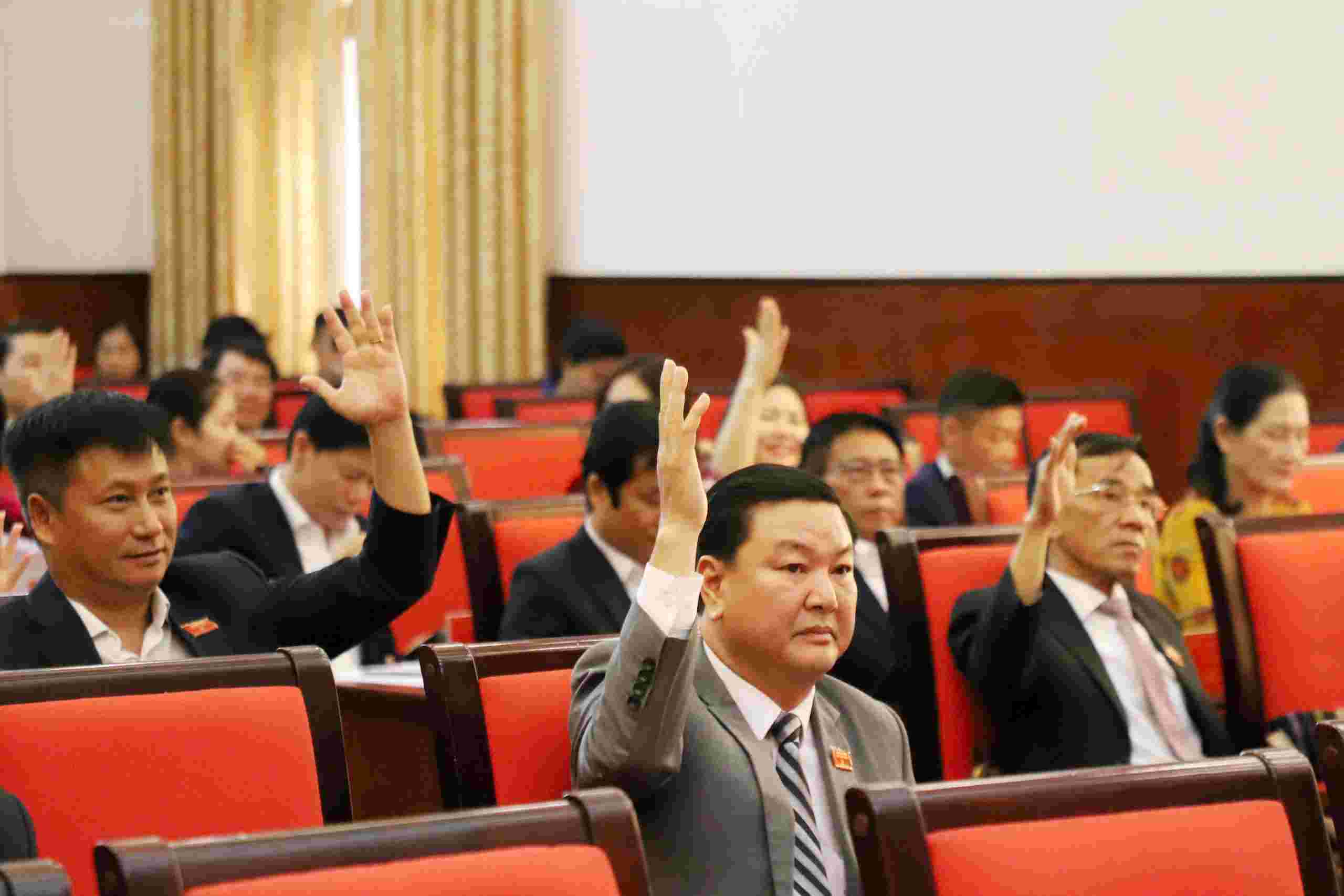 Provincial People's Council delegates voted to approve the merger, establishment and arrangement of specialized agencies under the Dak Nong Provincial People's Committee. Photo: Phan Tuan