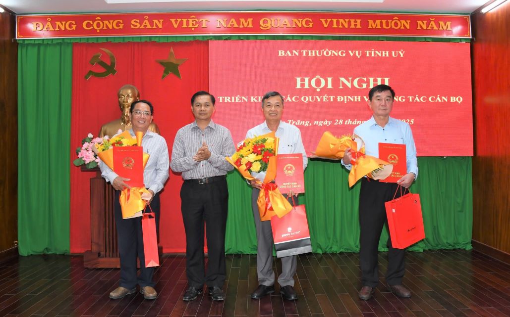 Dong chi Tran Van Lau - Pho Bi thu Tinh uy, Chu tich UBND tinh Soc Trang (thu 2 tu trai qua) trao quyet dinh va tang hoa cho cac dong chi: Tran Phuoc Vinh (thu 2 tu phai qua); Chau Kien Tuong (bia phai); Huynh Van Nam (bia trai)