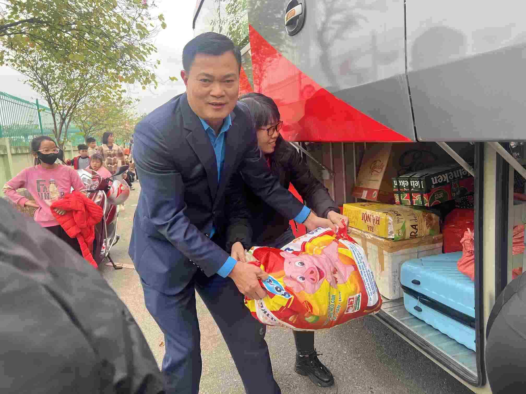 Mr. Nguyen Dinh Thang - Chairman of the Hanoi Industrial and Export Processing Zones Trade Union - helps pick up luggage on the Union's bus to pick up workers returning to Hanoi on the 5th day of Tet. Photo: Kieu Vu