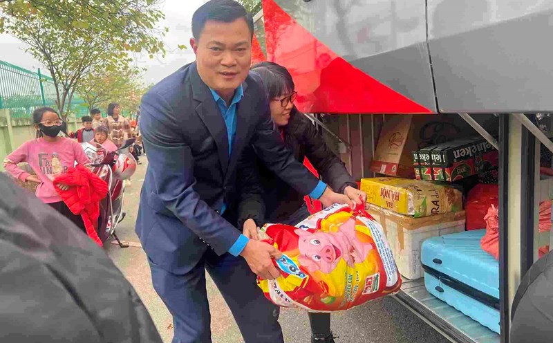 Mr. Nguyen Dinh Thang - Chairman of the Hanoi Industrial and Export Processing Zones Trade Union - helps pick up luggage on the Union's bus to pick up workers returning to Hanoi on the 5th day of Tet. Photo: Kieu Vu