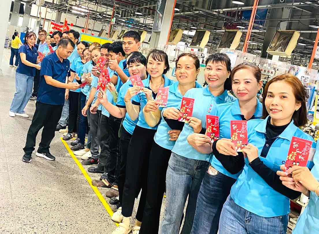 Management staff give lucky money to workers of Chang Shin Vietnam Company Limited (Dong Nai) on the first working day after Tet holiday. Photo: CDCC