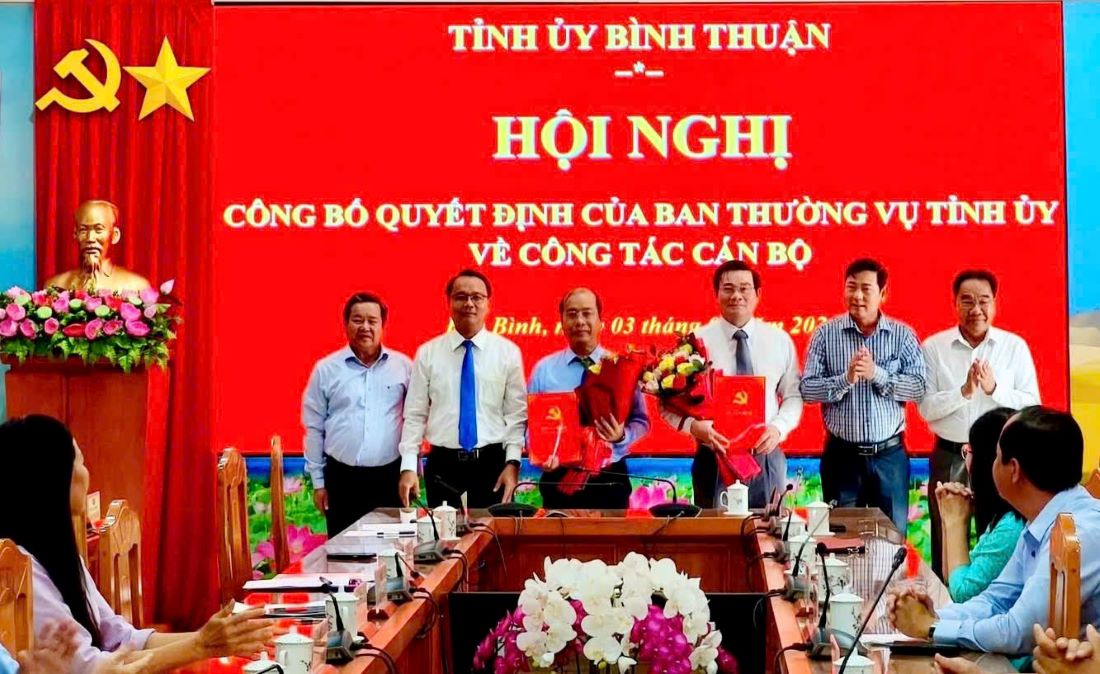 Trao quyet dinh va tang hoa chuc mung hai can bo duoc dieu dong. Anh: Bac Binh