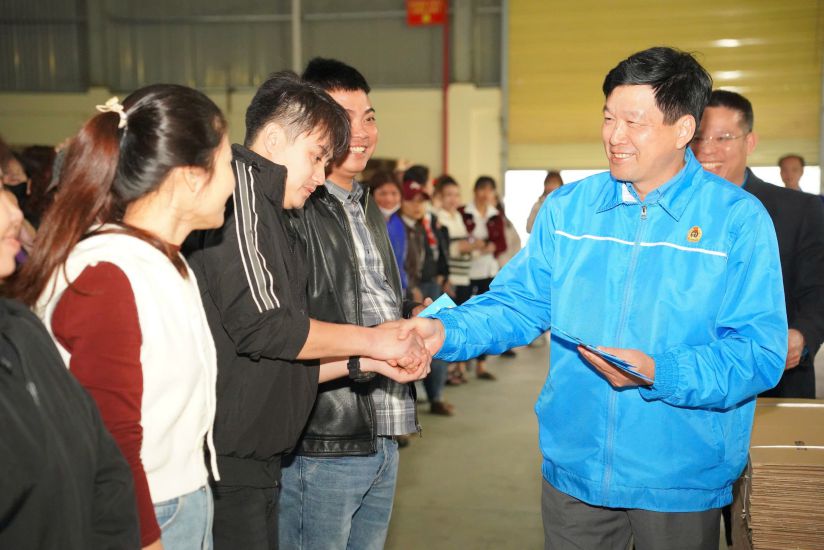 Chairman of Nghe An Provincial Labor Federation Kha Van Tam gives lucky money to workers on the first working day of the year. Photo: Quang Dai