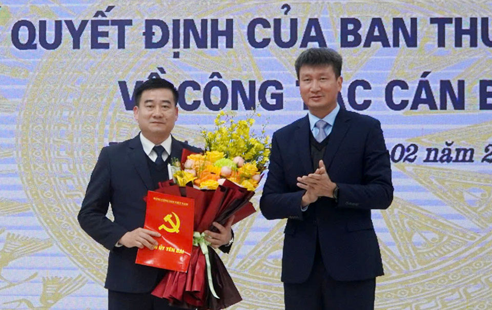 Bi thu Tinh uy Yen Bai Tran Huy Tuan trao Quyet dinh va tang hoa chuc mung tan Bi thu Huyen uy Van Yen Ha Duc Anh. Anh: Duc Toan 