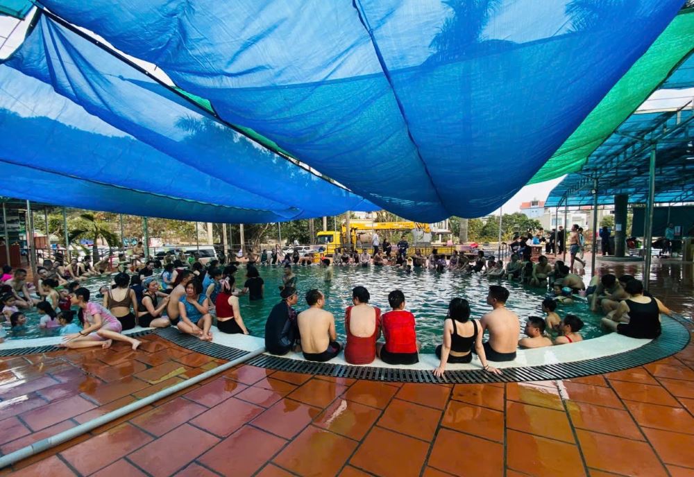 Người dân ngồi kín xung quanh bể bơi Trung tâm Điều dưỡng Khoáng nóng Địa chất, TP Cẩm Phả, tỉnh Quảng Ninh sau khi tắm, bơi, dù ngoài trời rất lạnh. Ảnh: Nguyễn Hùng