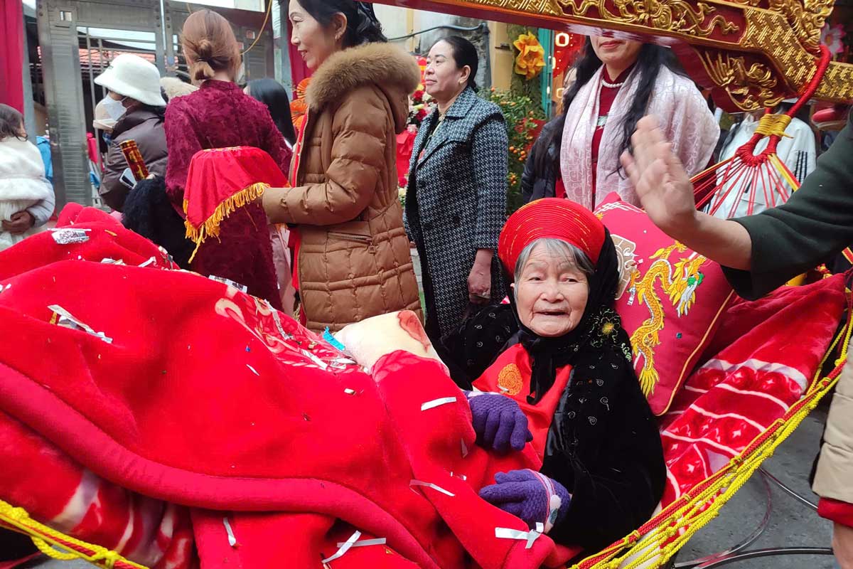 An old woman is carried by her children and grandchildren on a palanquin to Tien Cong Temple (Quang Yen Town, Quang Ninh) to perform the ancestor worship ceremony. Photo: Doan Hung