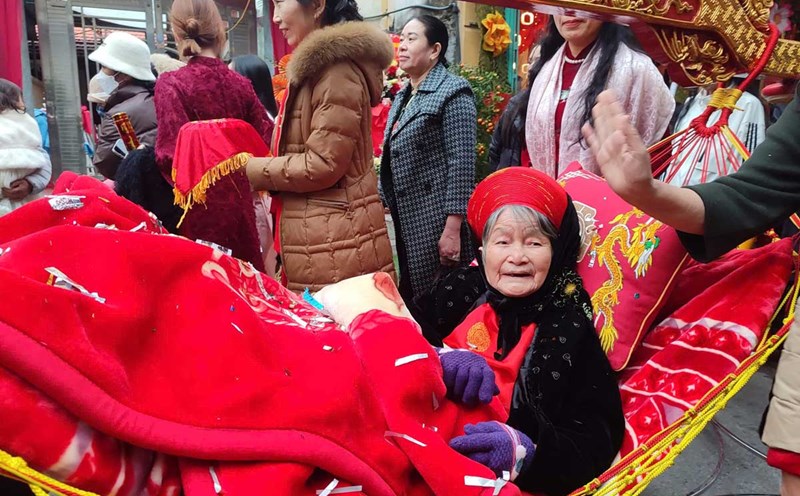 An old woman is carried by her children and grandchildren on a palanquin to Tien Cong Temple (Quang Yen Town, Quang Ninh) to perform the ancestor worship ceremony. Photo: Doan Hung