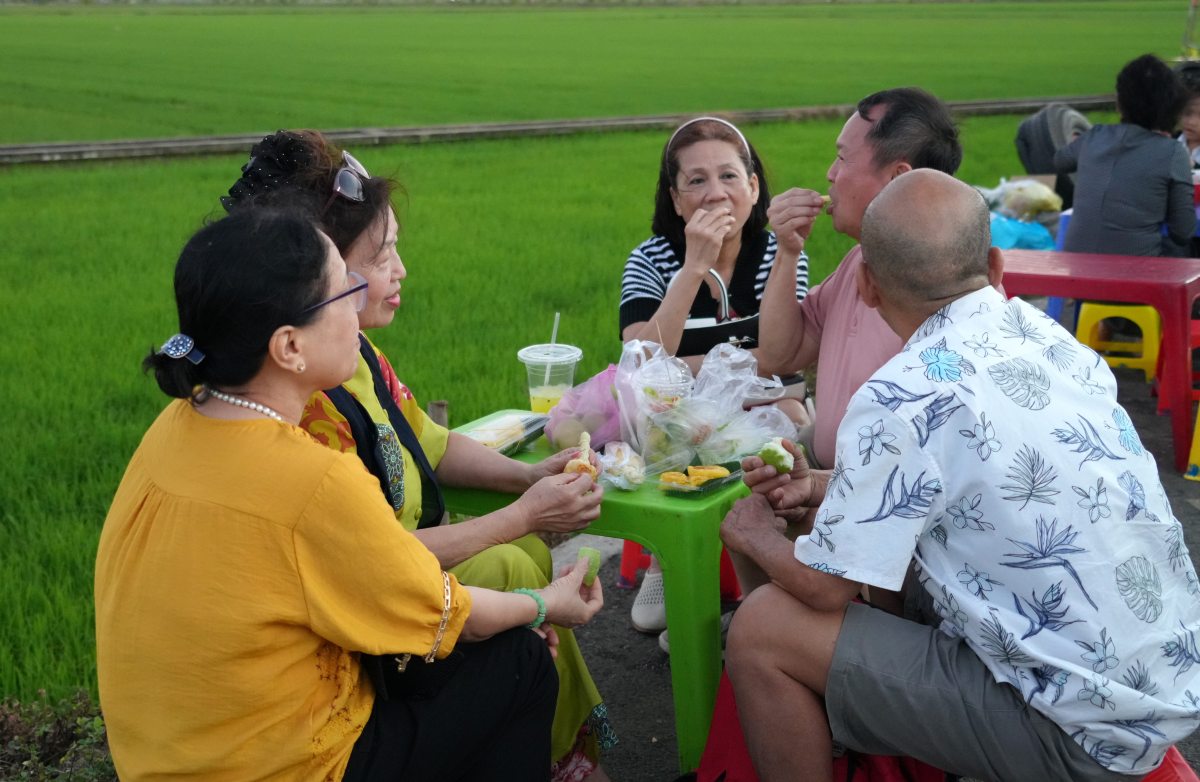 Thanh thoi thuong thuc cac mon an ben canh dong xanh ngat, long gio. Ong Nguyen Tan Phuc (ao hong, ngu TPHCM) cho biet: “Lan dau tien chung toi den cho que An Nhut, nhung rat thich thu voi mo hinh nay. Du ca nhom chi an chay, nhung chung toi cung tim duoc nhung mon phu hop. Chung toi se ru them nhung ban be va quay tro lai day vao dip khac“. Anh: Thanh An