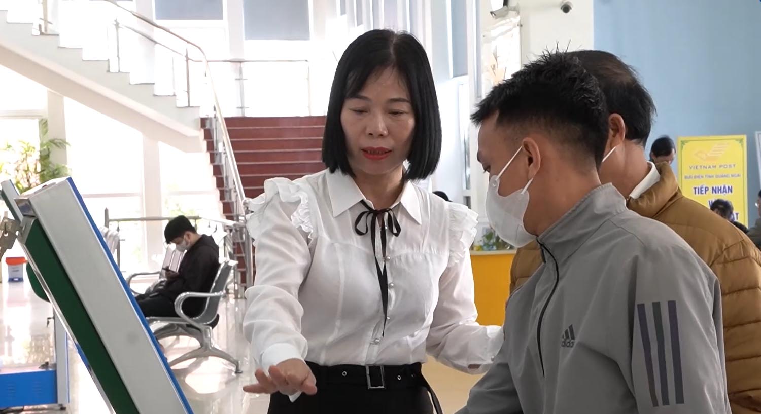 Cong chuc, vien chuc tai Trung tam phuc vu kiem soat thu tuc hanh chinh tinh Quang Ngai huong dan nguoi dan lam cac thu tuc hanh chinh. Anh: Vien Nguyen.