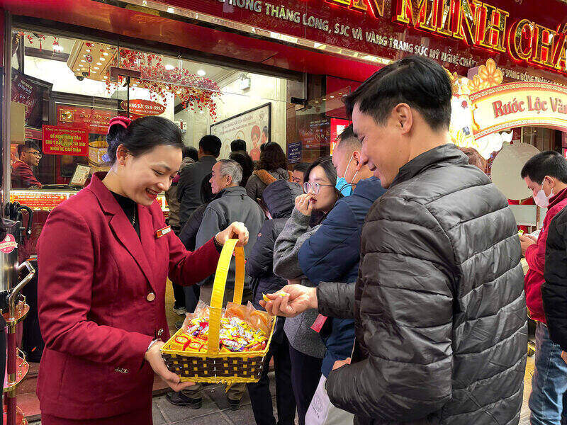 Cua hang vang xep ghe, moi khach an keo banh luc cho doi den luot mua vang de tranh khach bo ve. Anh: Thanh Binh.