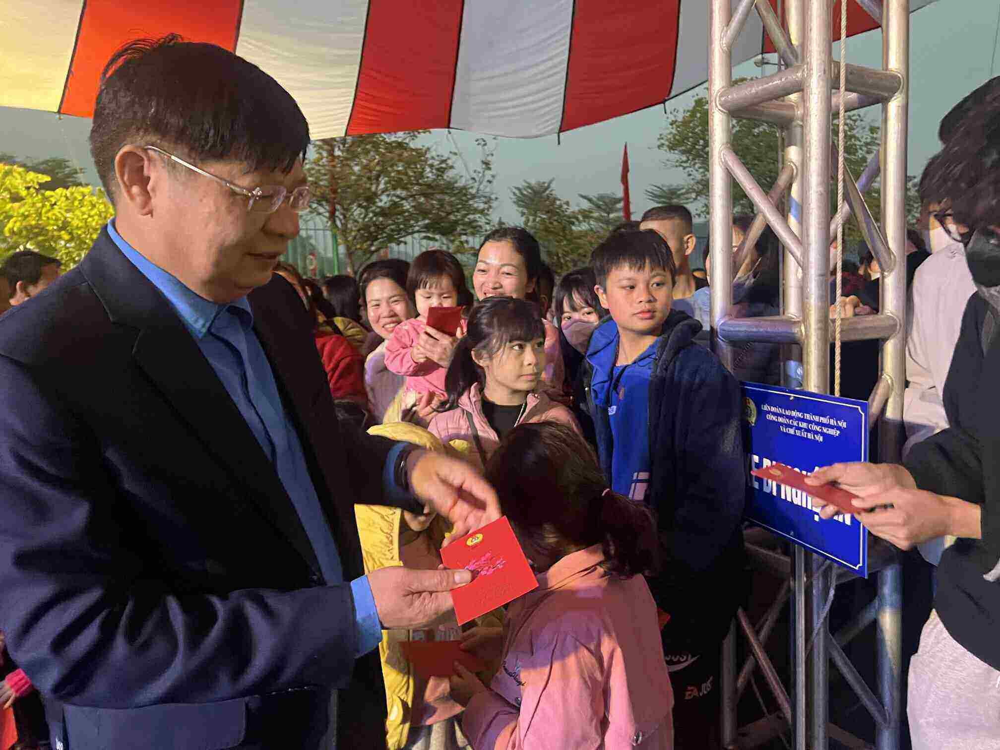 Vice President of the Vietnam General Confederation of Labor Phan Van Anh gives lucky money to workers' children before returning home for Tet by car organized by the Hanoi trade union. Photo: Kieu Vu