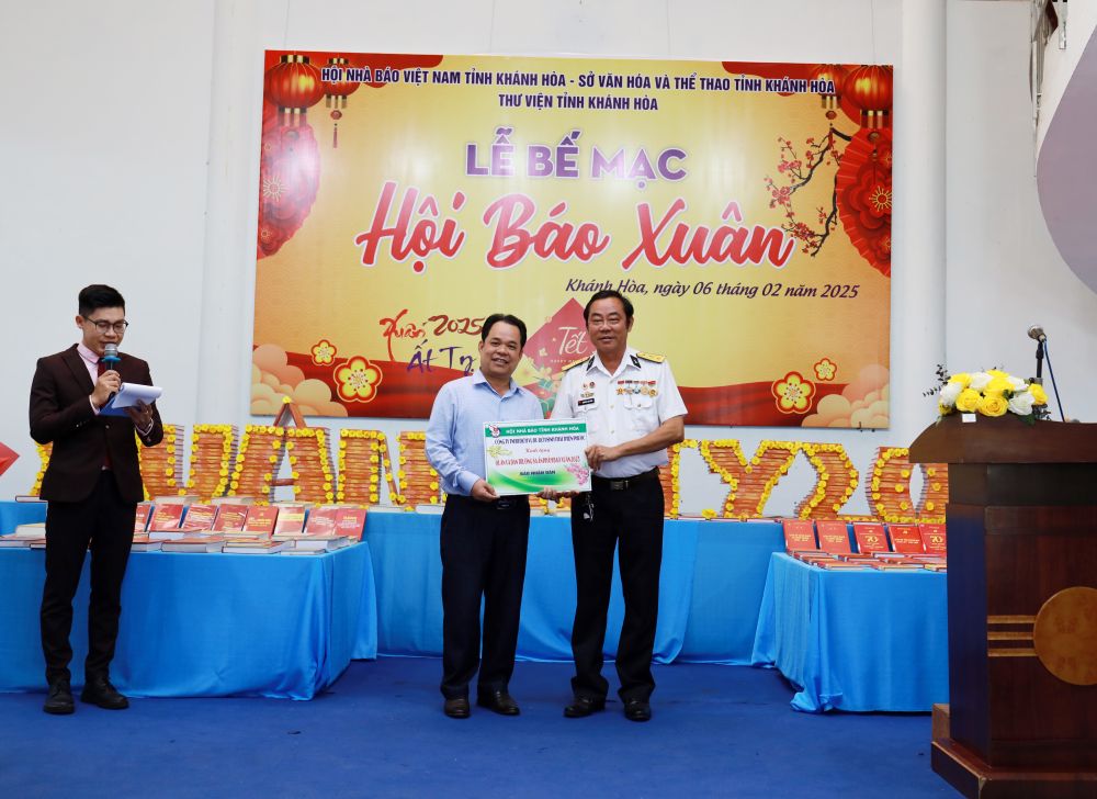 Leaders of Truong Sa District People's Committee received a symbolic board of the spring newspaper donated by the enterprise. Photo: Van Dong