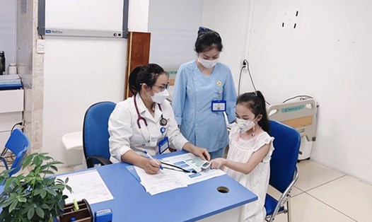 Bác sĩ Ngọc thăm khám cho bệnh nhi mắc cúm. Ảnh: BVCC