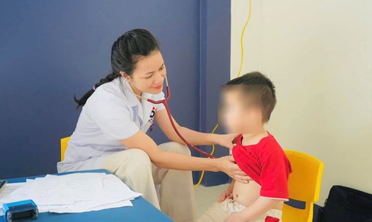 Bác sỹ Bệnh viện Sản Nhi Nghệ An khám cho bệnh nhi bị cúm mùa. Ảnh: Hoàng Yến