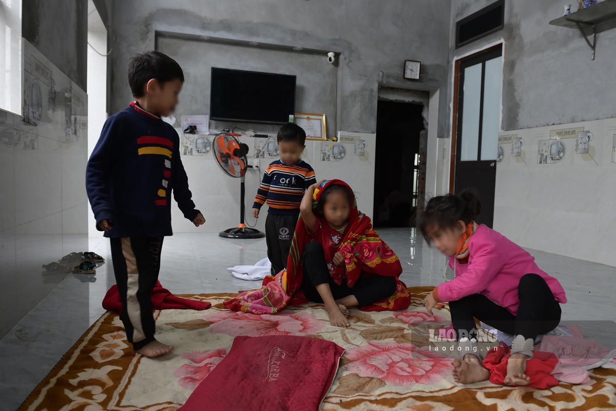 4 children playing together on a blanket spread on the cold floor. Photo: Ha Vi