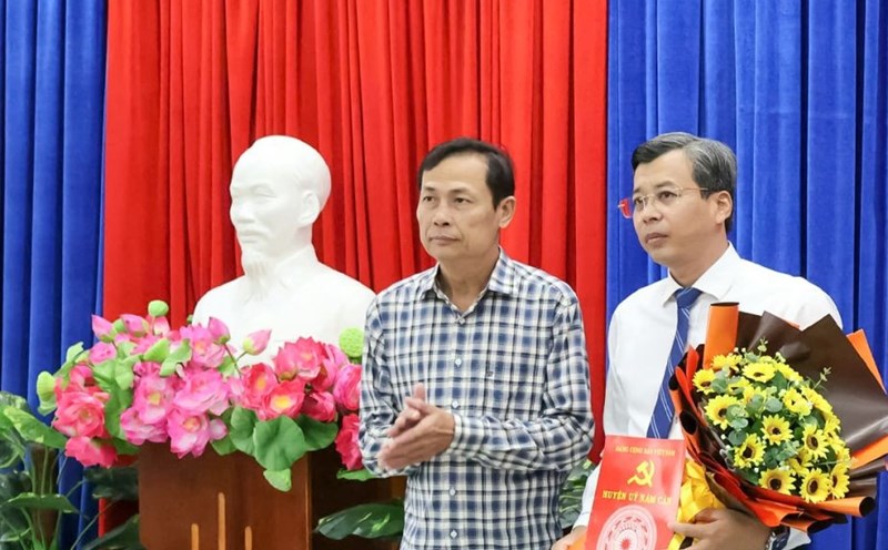 Secretary of the District Party Committee Nam Can Luc Trong Quyen (left) presented the decision to merge the District Party Committee's Propaganda Department and the District Party Committee's Mass Mobilization Committee into the District Party Committee's Propaganda and Mass Mobilization Department to comrade Huynh Viet Trieu, Head of the District Party Committee's Propaganda and Mass Mobilization Department. Photo: Ca Mau Newspaper