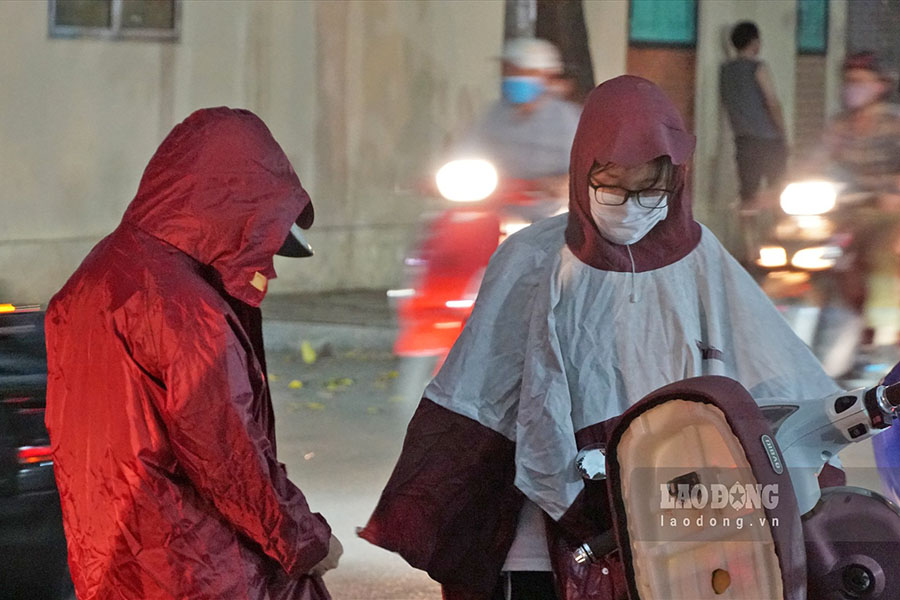 Khi dừng xe mặc áo mưa trên đường, cần đảm bảo an toàn giao thông. Ảnh: Hoàng Vũ