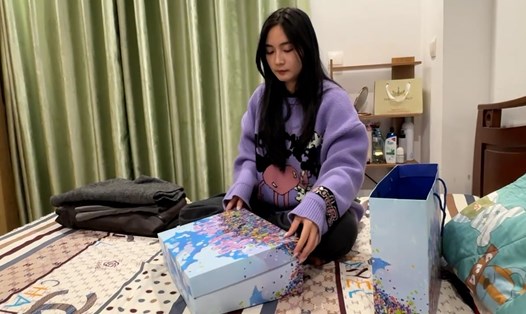 Chị Phương Anh đóng gói những món đồ cũ để gửi cho khách. Ảnh: Ngọc Linh