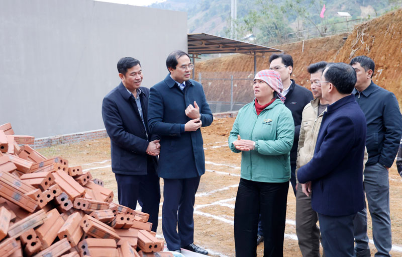 Bí thư Tỉnh ủy Lào Cai Trịnh Xuân Trường (thứ 2 từ trái sang) thăm hỏi gia đình các hộ dân được hỗ trợ xây nhà mới. Ảnh: Cao Cường